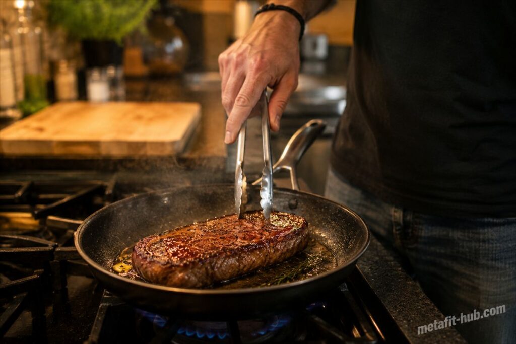 フライパンで厚切りステーキを焼いている、モチベーションアップしたい筋トレ民向けご褒美肉ランキング記事のH1画像
