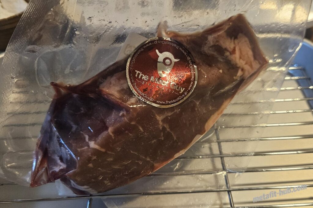 真空パックされたステーキ肉を焼く前に解凍して準備している画像