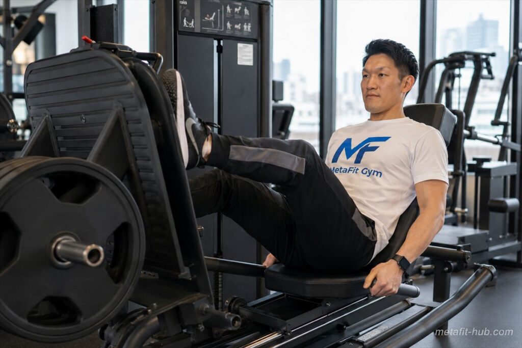ジムのレッグプレスマシンでトレーニングを行う男性モデル。大腿四頭筋・臀筋・ハムストリングスを鍛える筋トレ種目のフォームイメージ